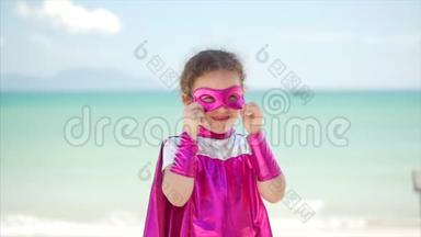 美丽的小女孩在超级<strong>英雄</strong>服装，穿着粉红色斗篷和面具的<strong>英雄</strong>。 坐在飞机上